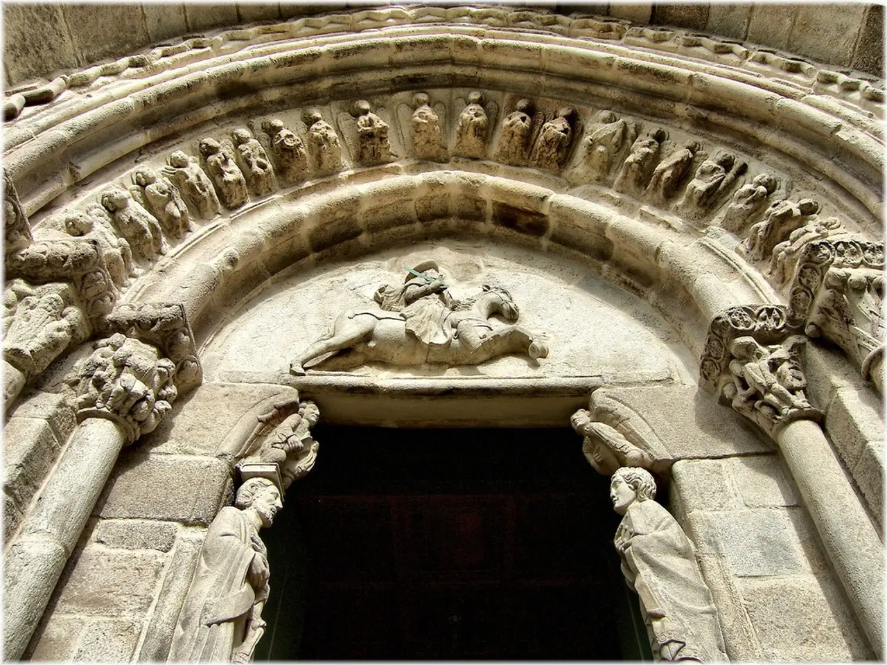 In this image we can see the arch on the building. There are many sculptures on the wall. There are...