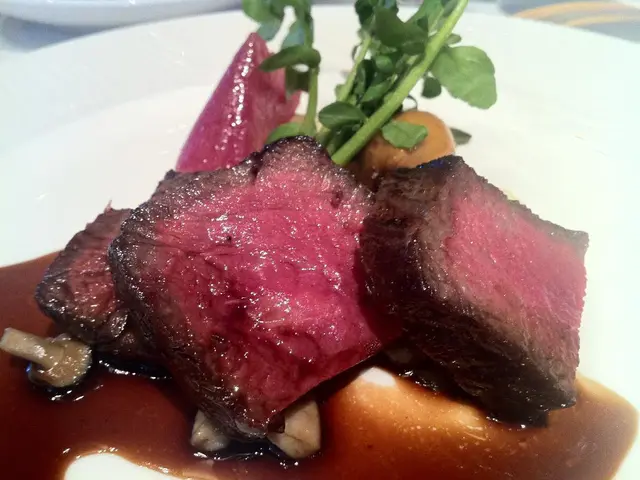 In this image we can see some food containing meat, mushrooms and leaves in a plate.