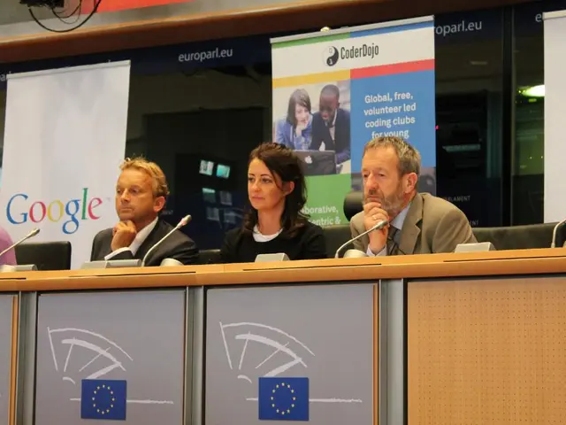 In this image I can see four persons are sitting on chairs and in the front of them I can see four...