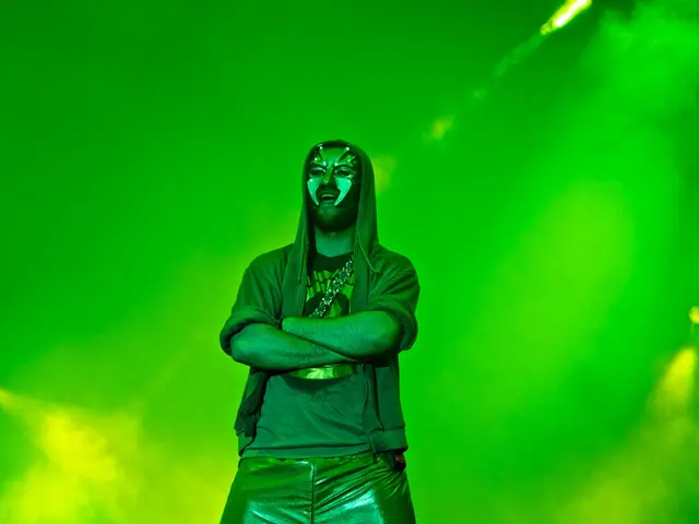 In the middle of the image a man is standing and he wears a mask. Behind him there is fog and...